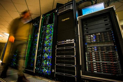 wall of high processing computers with a blurred image of a person walking in front of them